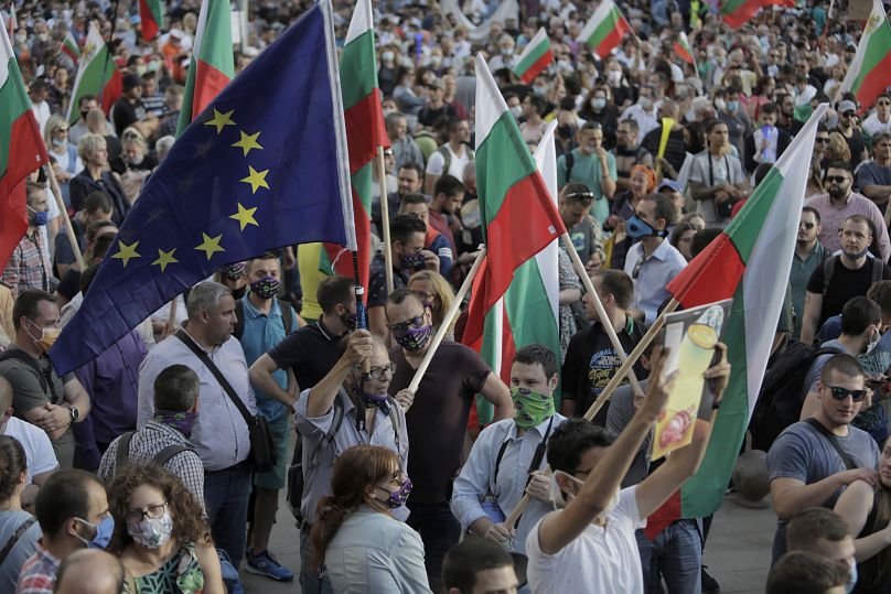 Protesters wave Bulgarian and EU flags as they take part in anti-governmental protest in downtown Sofia on Monday, July 13, 2020