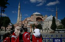Török zászlóba burkolt emberek az átalakítás miatt bezárt isztambuli látványosság, az Hagia Sophia előtt