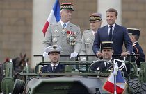 France's President Emmanuel Macron stands in the command car as he reviews troops before the start of the Bastille Day parade. 14 July, 2020.