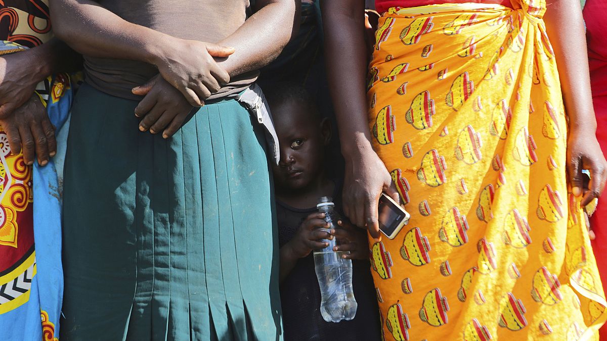 A child pictured in February standing between women waiting to receive food parcels in Zimbabwe, where the UN estimates more than half the population is in need of food assist