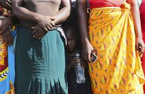 A child pictured in February standing between women waiting to receive food parcels in Zimbabwe, where the UN estimates more than half the population is in need of food assist