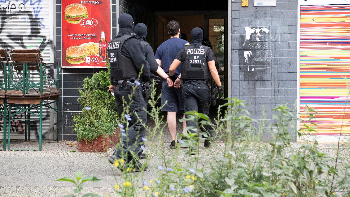عناصر الشرطة تعتقل رجلاً في مبنى في برلين، ألمانيا