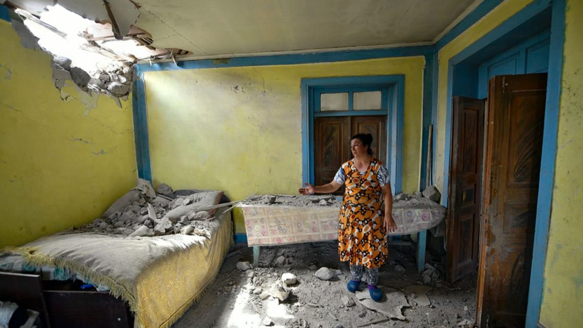 Azerbaycan'ın Tovuz bölgesinde yaşayan bir kadın Ermenistan ordusunun attığı toplardan birinin düştüğü evinin durumunu gösteriyor