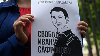 Сторонник Ивана Сафронова держит плакат в его поддержку.