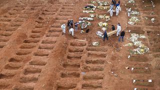 Cemetery workers in protective clothing bury three victims of the new coronavirus at the Vila Formosa cemetery in Sao Paulo, Brazil, Wednesday, July 15, 2020. 
