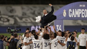 Real Madrid players throw head coach Zinedine Zidane in the air as they celebrate after winning the La Liga title.