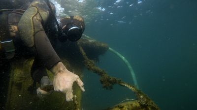 A diver pulls a shipwreck's rope during a raising operation, on Salamina island, west of Athens, on Wednesday, Feb. 13, 2020. A diver pulls a shipwreck's rope during a raising operation, on Salamina island, west of Athens, on Wednesday, Feb. 13, 2020.