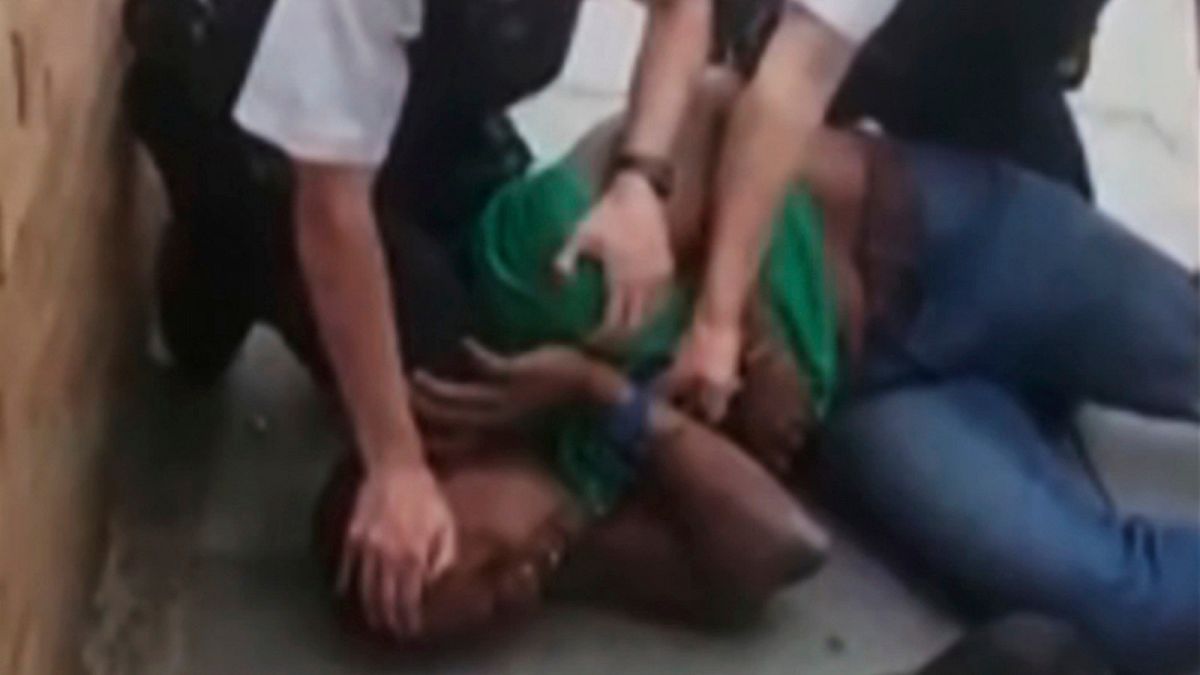 In this Thursday, July 16, 2020, image taken from video and provided by @RealAiRavish, police appear to kneel on a black man's neck during an arrest in north London