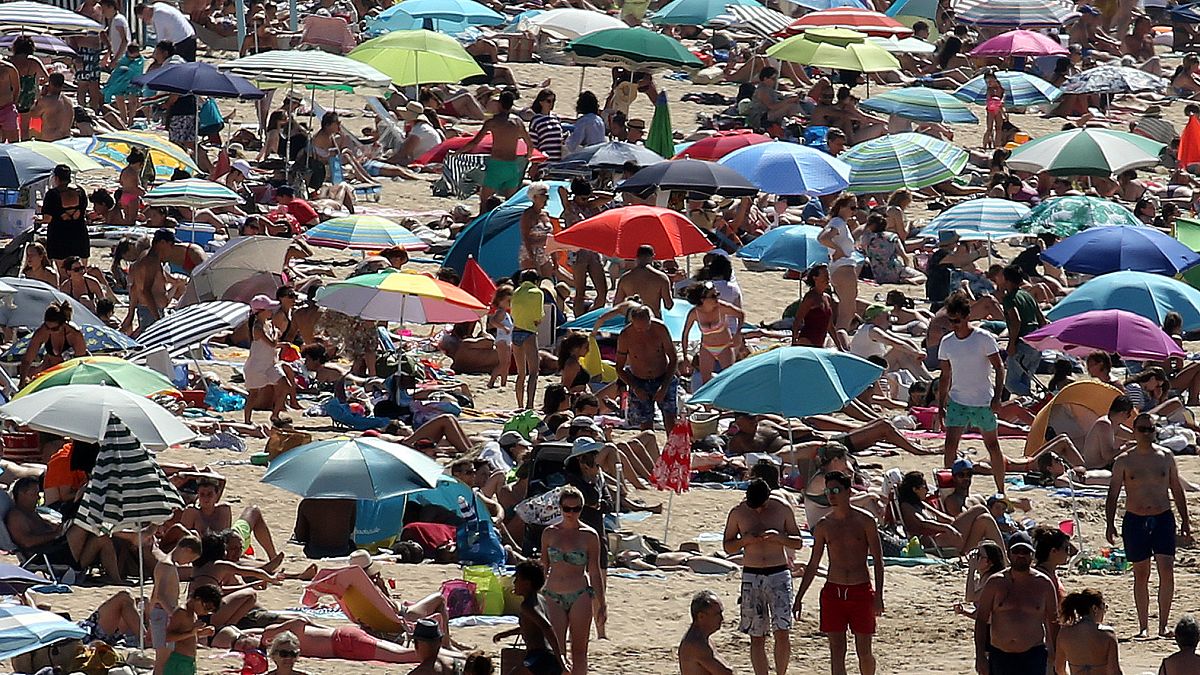 La gente toma el sol en la playa de San Juan de Luz, en el suroeste de Francia, el sábado 18 de julio.