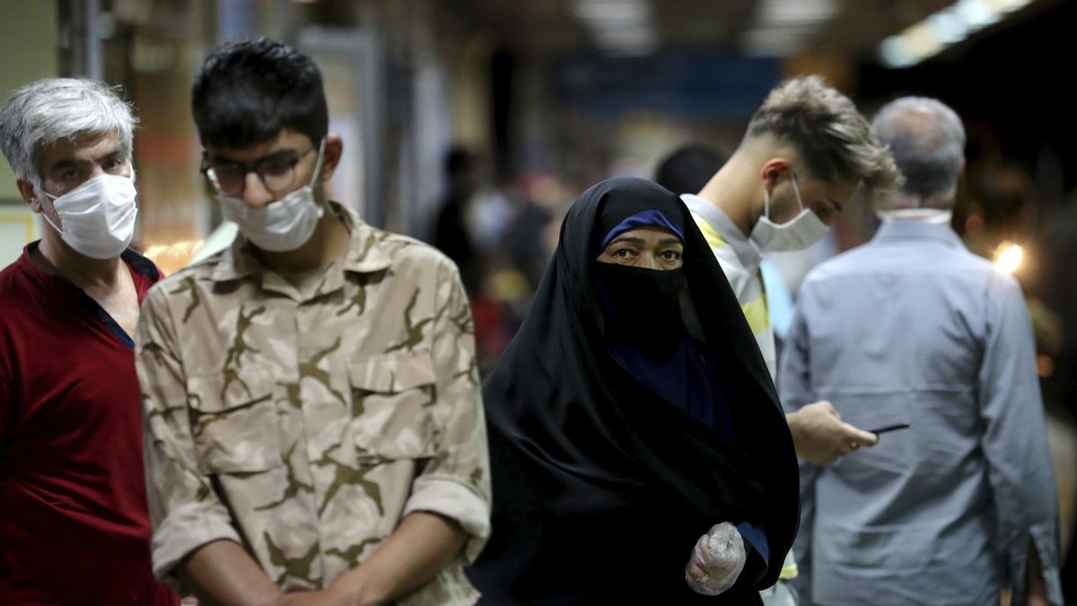People wearing protective face masks to help prevent the spread of the coronavirus walk in a metro station, in Tehran, Iran
