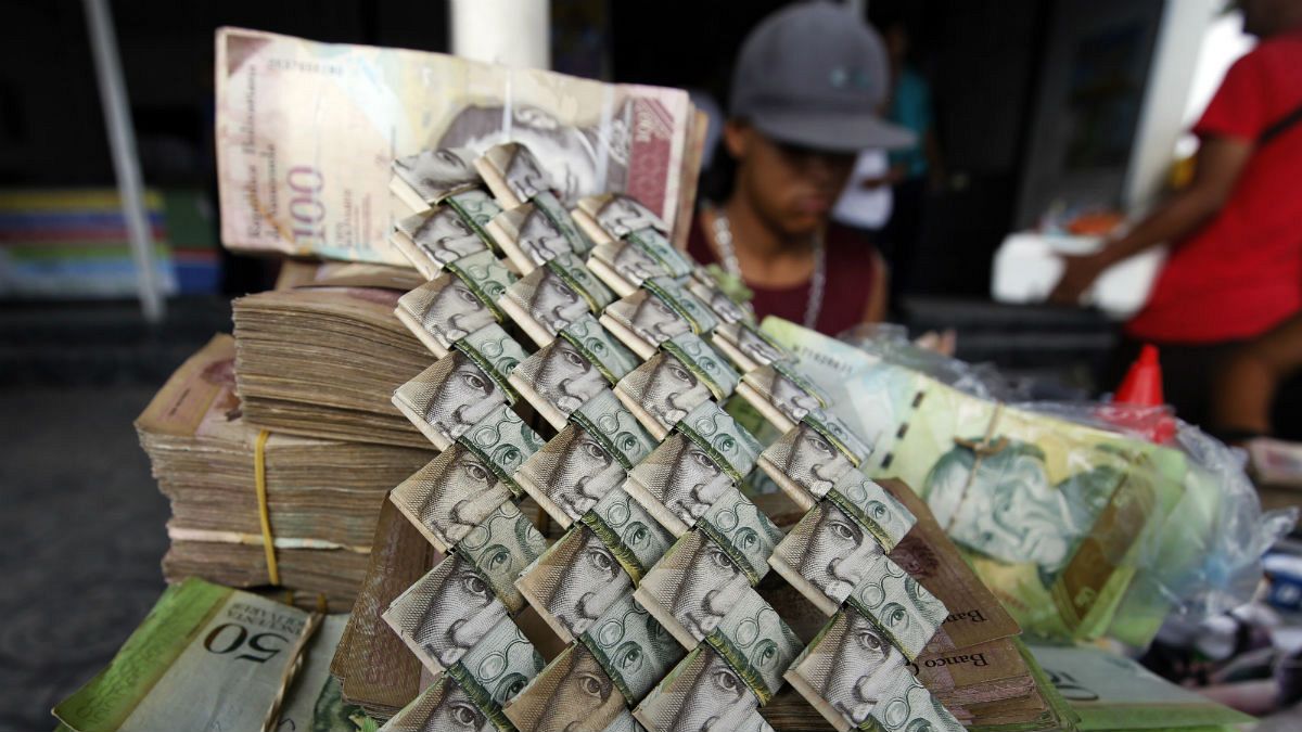 Venezuelan Bolivars are weaved together at a vendor's table selling art and bags made from the currency