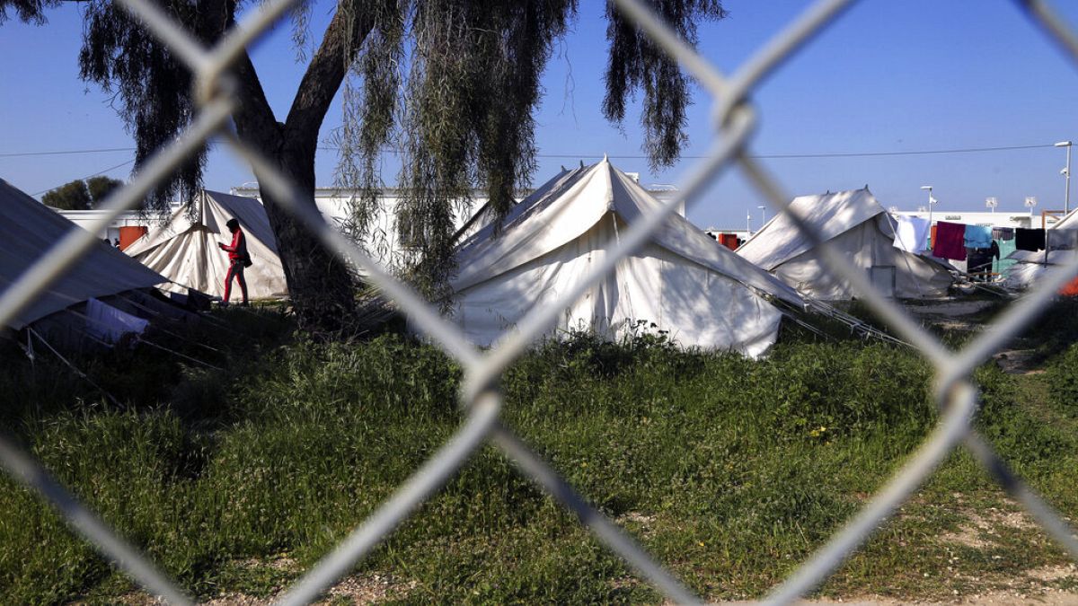 A migrant walks by the tents inside a refugee camp in Kokkinotrimithia outside of Nicosia, Cyprus, Tuesday, March 3, 2020.