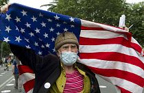 An elderly activist, wearing a face mask to protect against coronavirus, waves the US flag during a rally in Tbilisi, Georgia