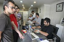 Iranians exchange currencies in a money exchange bureau, in downtown Tehran, Iran
