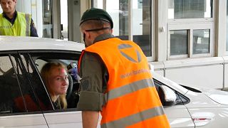 A woman crossing the Austrian border from Slovenia gets her temperature checked.