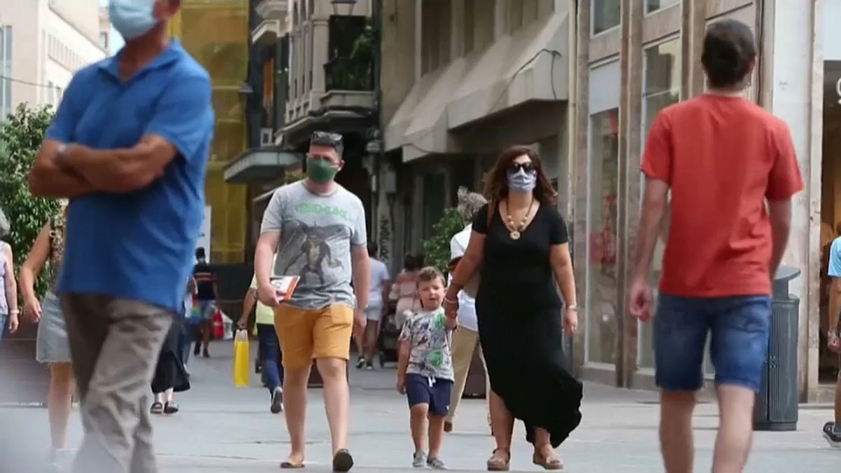 Una familia con mascarillas caminando por la calle