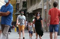 Una familia con mascarillas caminando por la calle