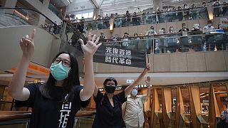Protesters show a banner "Librate Hong Kong, Revolution of out time" in a shopping mall