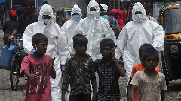 Hindistan'ın Mumbai kentinde Covid-19 testi yapmak için bir semte giden sağlık görevlileri Hindistan'ın Mumbai kentinde Covid-19 testi yapmak için bir semte giden sağlık görevlileri