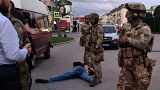 An assailant, who seized a bus with hostages, lies on the ground after police officers detained him in the city centre of Lutsk, some 400 kilometres west of Kyiv, Ukraine