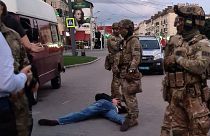 An assailant, who seized a bus with hostages, lies on the ground after police officers detained him in the city centre of Lutsk, some 400 kilometres west of Kyiv, Ukraine