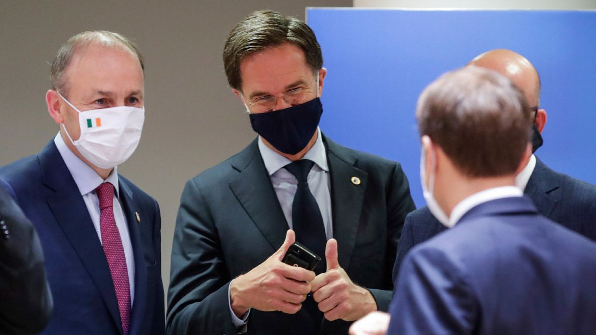 Dutch Prime Minister Mark Rutte, centre, speaks with French President Emmanuel Macron and Ireland's Prime Minister Micheal Martin, at the EU summit in Brussels, Tuesday