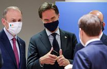 Dutch Prime Minister Mark Rutte, centre, speaks with French President Emmanuel Macron and Ireland's Prime Minister Micheal Martin, at the EU summit in Brussels, Tuesday
