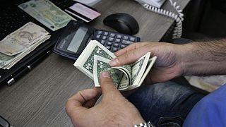 A currency exchange bureau worker counts U.S. dollars in downtown Tehran, Iran