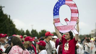 David Reinert holding a Q sign waits in line with others to enter a campaign rally with President Donald Trump and U.S. Senate candidate Rep. Lou Barletta, August 2018