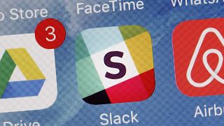 The Slack app is displayed on a mobile phone.