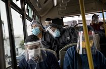 Commuters, wearing protective face masks and face shields, travel on a public bus in Lima, Peru, Wednesday, July 22, 2020.