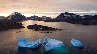 In this Aug. 16, 2019, photo, large Icebergs float away as the sun rises near Kulusuk, Greenland. 