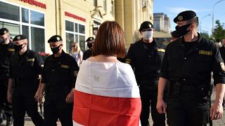 Belarus' riot police officers watch opposition supporters in Minsk on June 19, 2020.