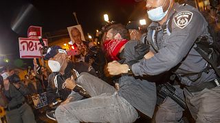 Israeli police officers arrest a demonstrator during a protest against prime minister Benjamin Netanyahu