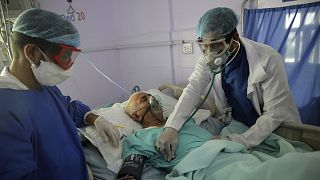 medical workers attend to a COVID-19 patient in an intensive care unit at a hospital in Sanaa, Yemen.