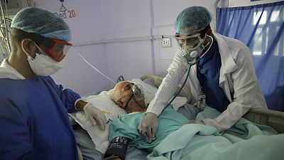medical workers attend to a COVID-19 patient in an intensive care unit at a hospital in Sanaa, Yemen.