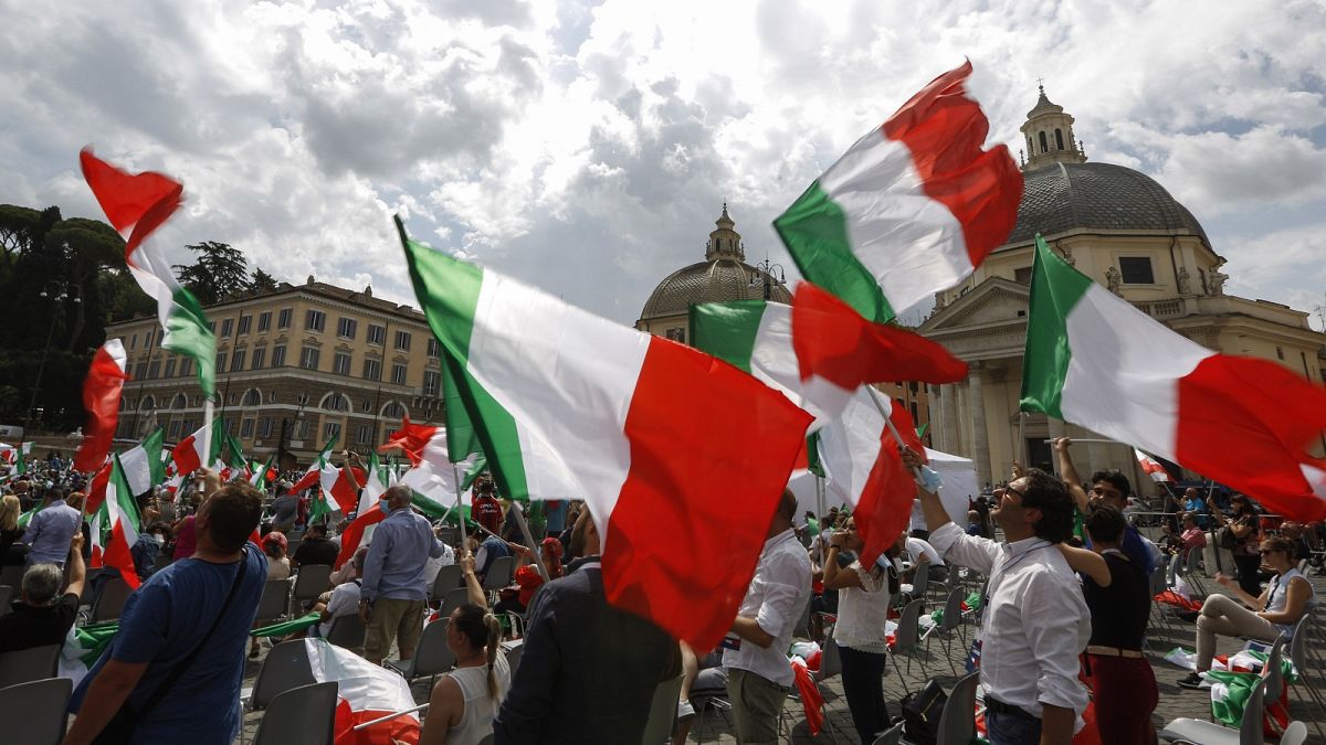 People wave Italian flags during a centre-right opposition rally in Rome's central Piazza del Popolo on July 4, 2020.