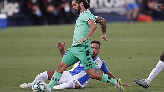 Real Madrid's Isco, is tackled by a Leganes' player during the Spanish La Liga soccer match between Leganes and Real Madrid.