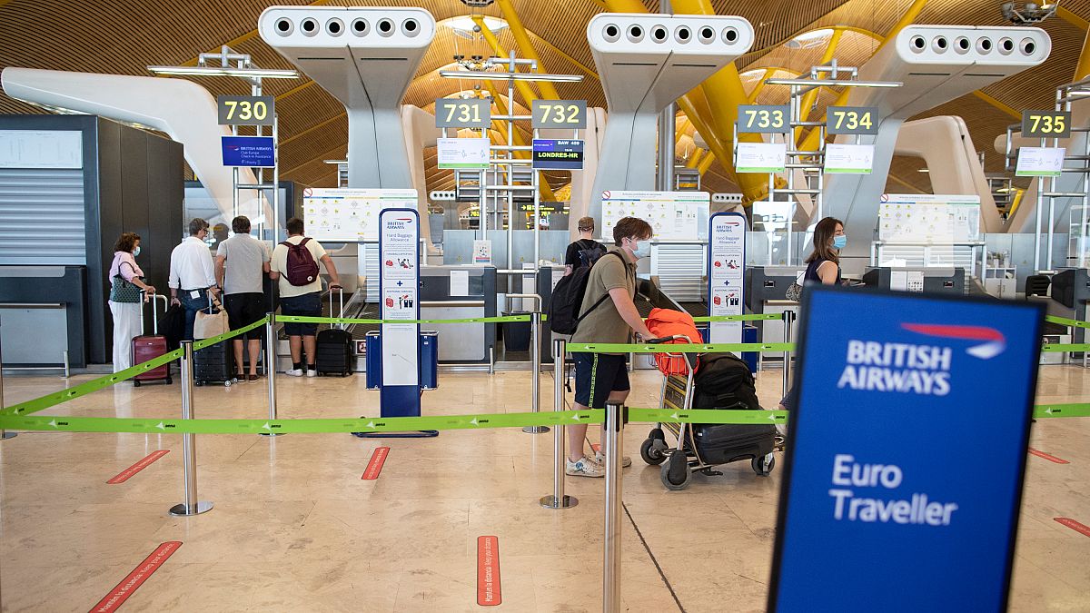 Pasajeros con mascarillas hacen cola antes de salir a Londres en el aeropuerto internacional de Barajas, Madrid, España, el 26 de julio de 2020.