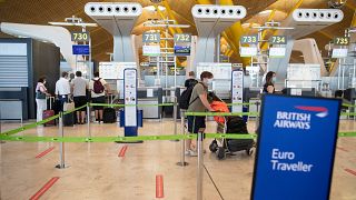Pasajeros con mascarillas hacen cola antes de salir a Londres en el aeropuerto internacional de Barajas, Madrid, España, el 26 de julio de 2020.