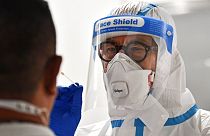 A doctor takes a COVID-19 test from a passenger who arrived at the airport in Duesseldorf, Germany, Monday, July 27, 2020