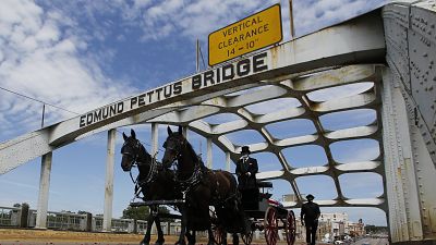 The casket of Rep. John Lewis moves over the Edmund Pettus Bridge by horse drawn carriage during a memorial service.