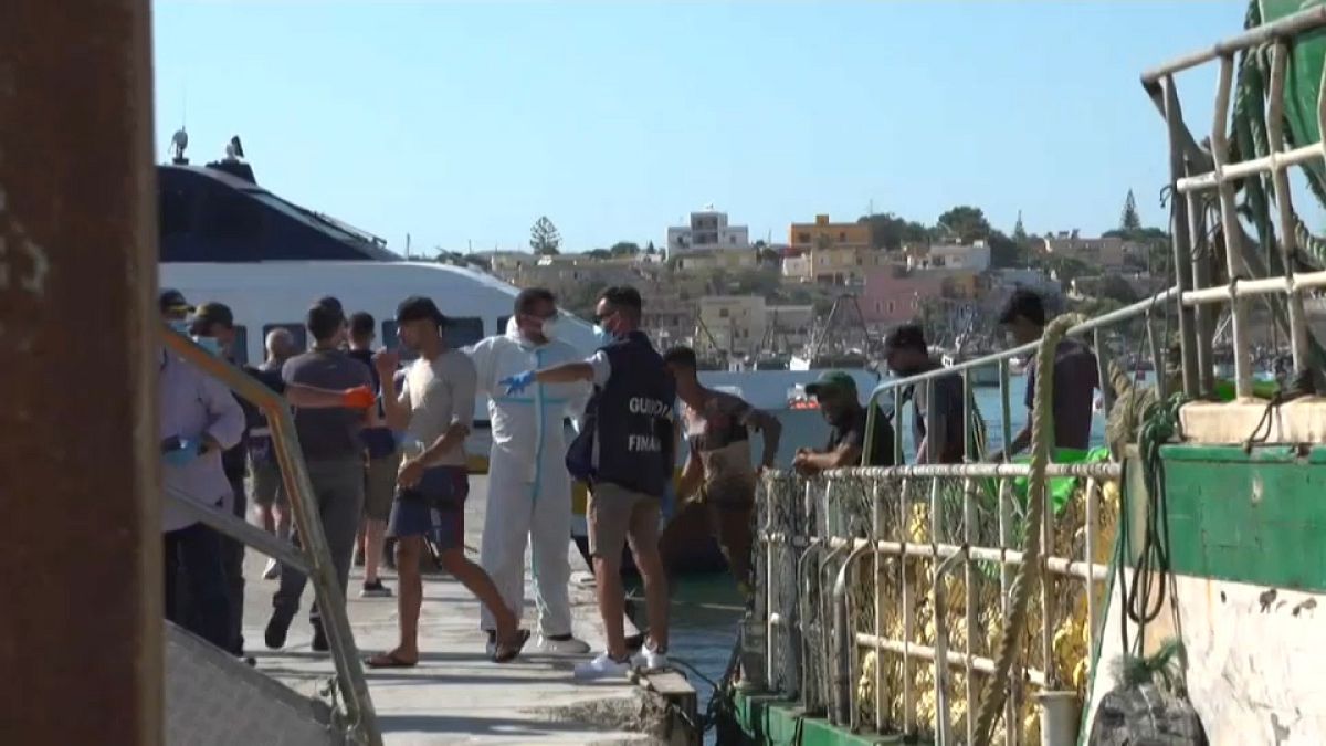 Un gruppo di migranti sbarca da un pescherecchio a Lampedusa