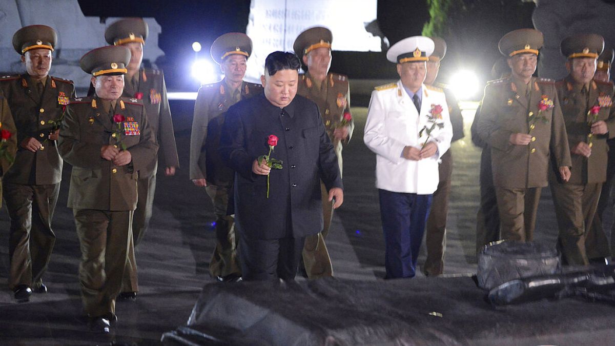 North Korean leader Kim Jong Un, center, with military officers in uniforms prepares to lay a flower to the Fatherland Liberation War Martyrs' Cemetery in Pyongyang.