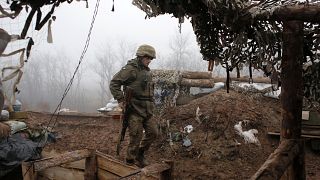 In this file photo dated Monday, Dec. 9 2019, a Ukrainian soldier takes position on the front line at the town of Novoluhanske in the Donetsk region, Ukraine. 