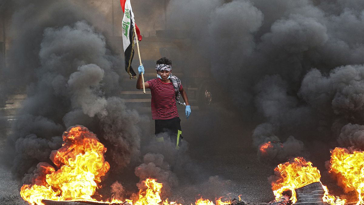 متظاهرون يحرقون إطارات أمام مبنى مجلس المحافظة خلال مظاهرة في البصرة، يوليو 2020