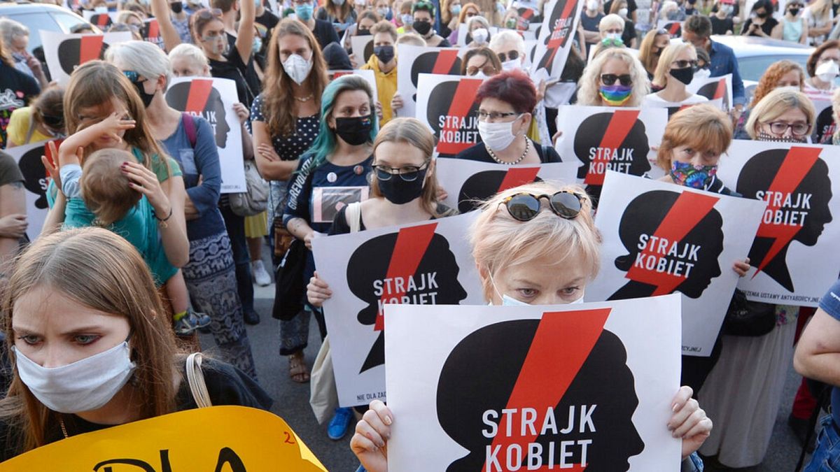 Protesters with a banner reading "Women's Strike" taking part in a rally against Polish government plans to withdraw from the Istanbul Convention on prevention and combatting 