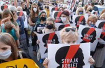 Protesters with a banner reading "Women's Strike" taking part in a rally against Polish government plans to withdraw from the Istanbul Convention on prevention and combatting 