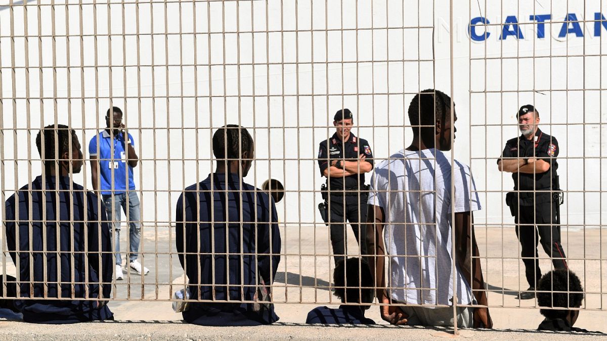 Migrants wait to be transferred to Porto Empedocle from Lampedusa, in Sicily, Monday, Aug. 19, 2019