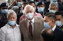 Former Malaysian Prime Minister Najib Razak, center, wearing a face mask with his supporters arrives at courthouse in Kuala Lumpur, Malaysia, Tuesday, July 28, 2020.